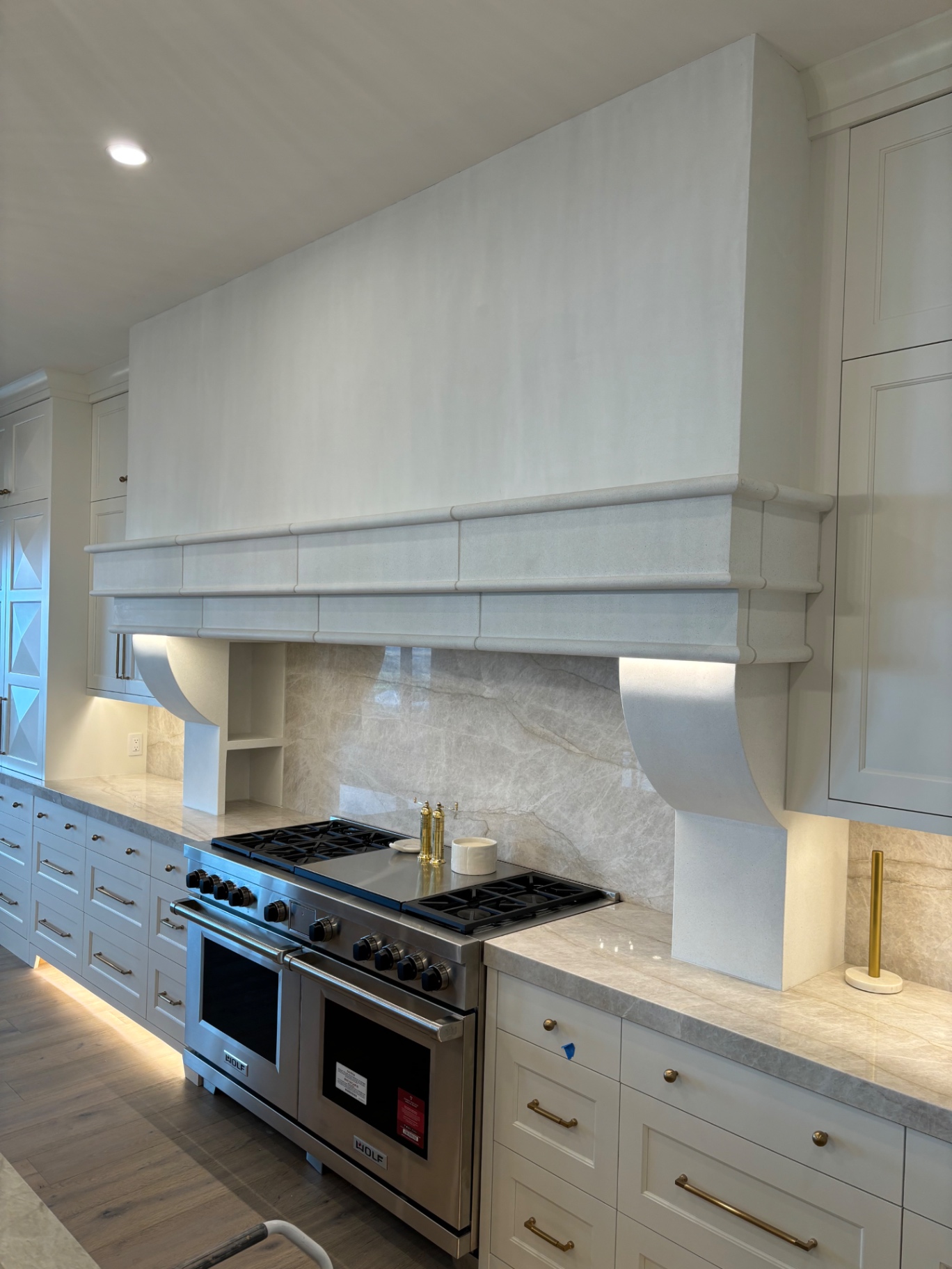 Plaster range hood with hand-shaped corbels in a custom kitchen