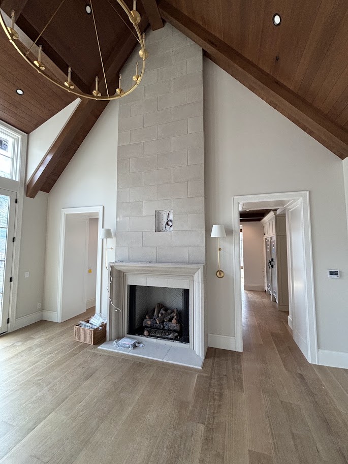 Vaulted great room with a full-height cast limestone fireplace surround