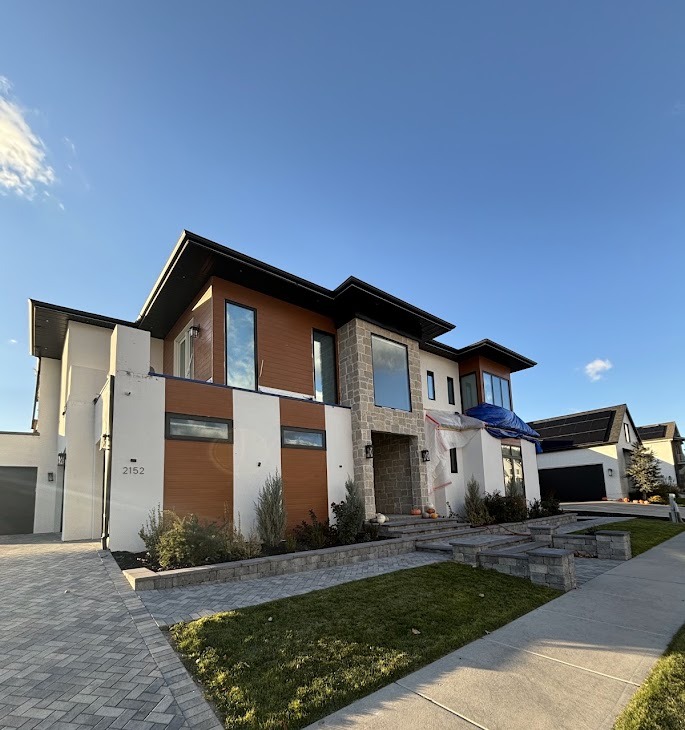 Contemporary home with white stucco, wood siding, and stone accents