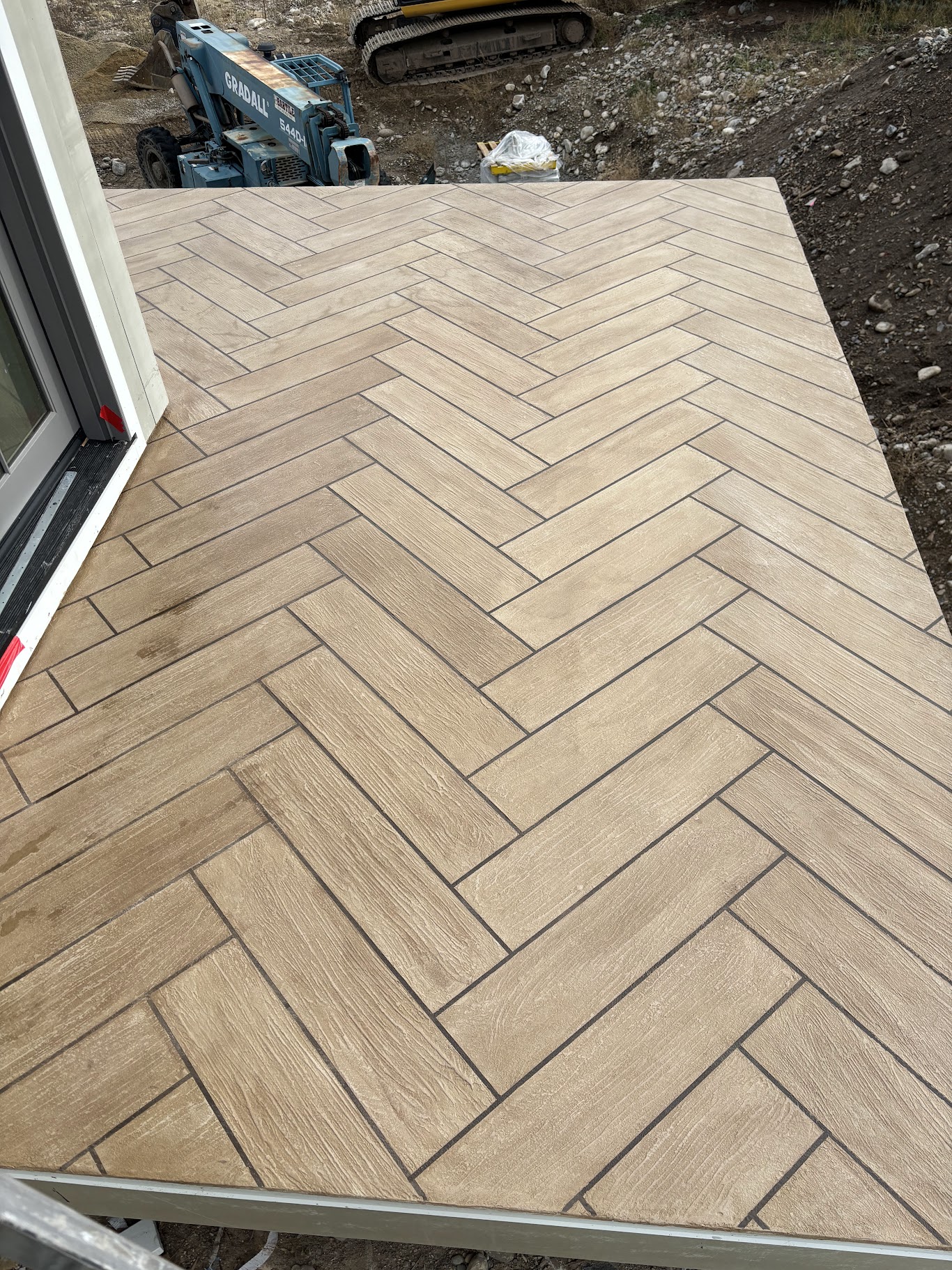 Herringbone wood-look deck coating near a home entrance