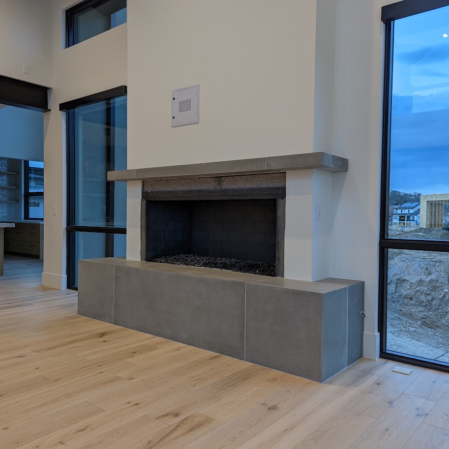 Contemporary cast stone fireplace mantel and hearth bench in a great room
