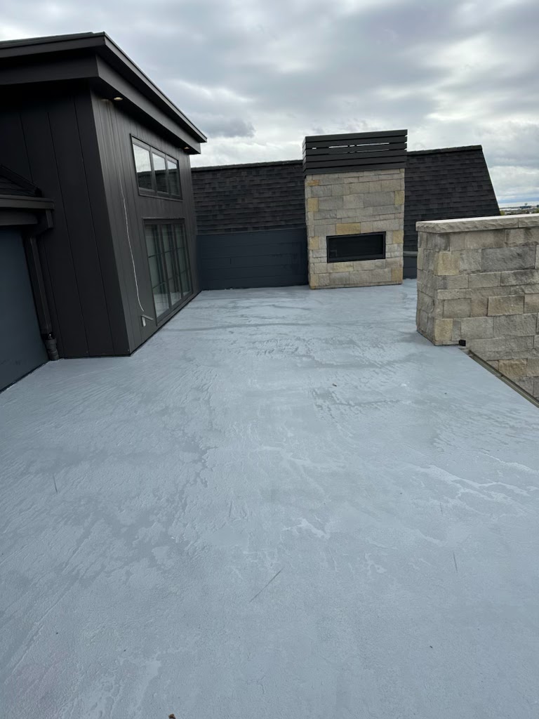 Waterproof deck surface with stone fireplace and modern home exterior