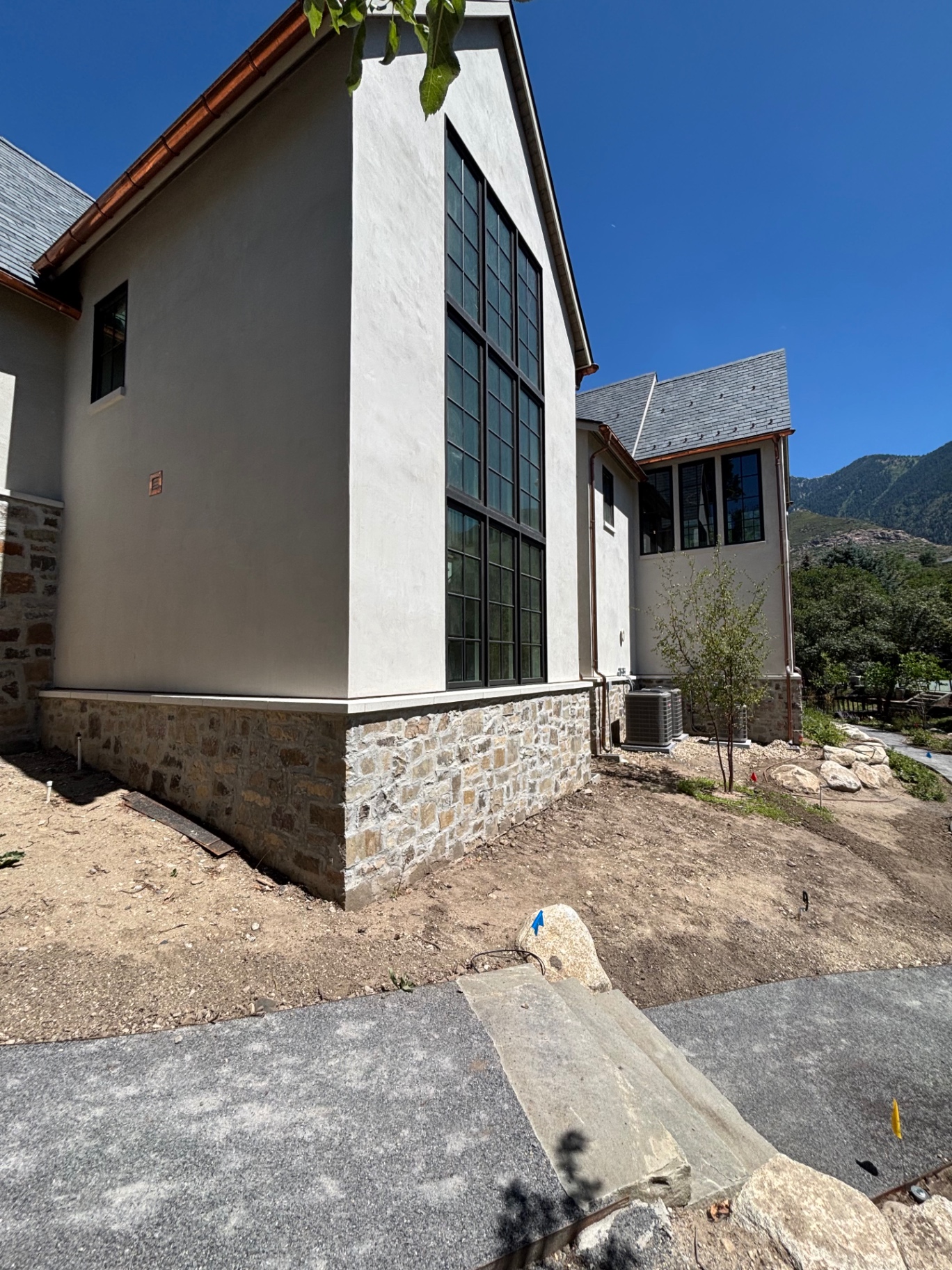 Stucco home exterior with natural stone wainscot