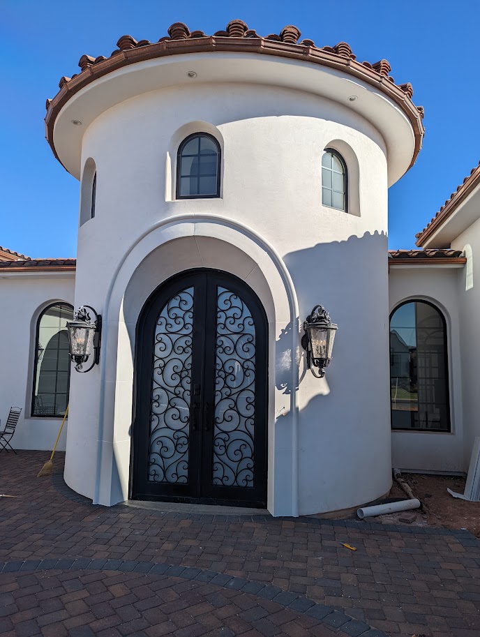 Stucco turret entry with cast limestone arch and trim detail