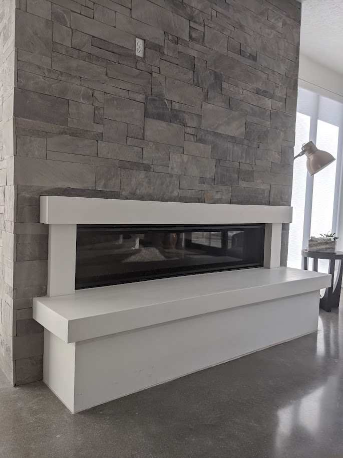 Modern white cast limestone mantel and hearth bench with linear firebox