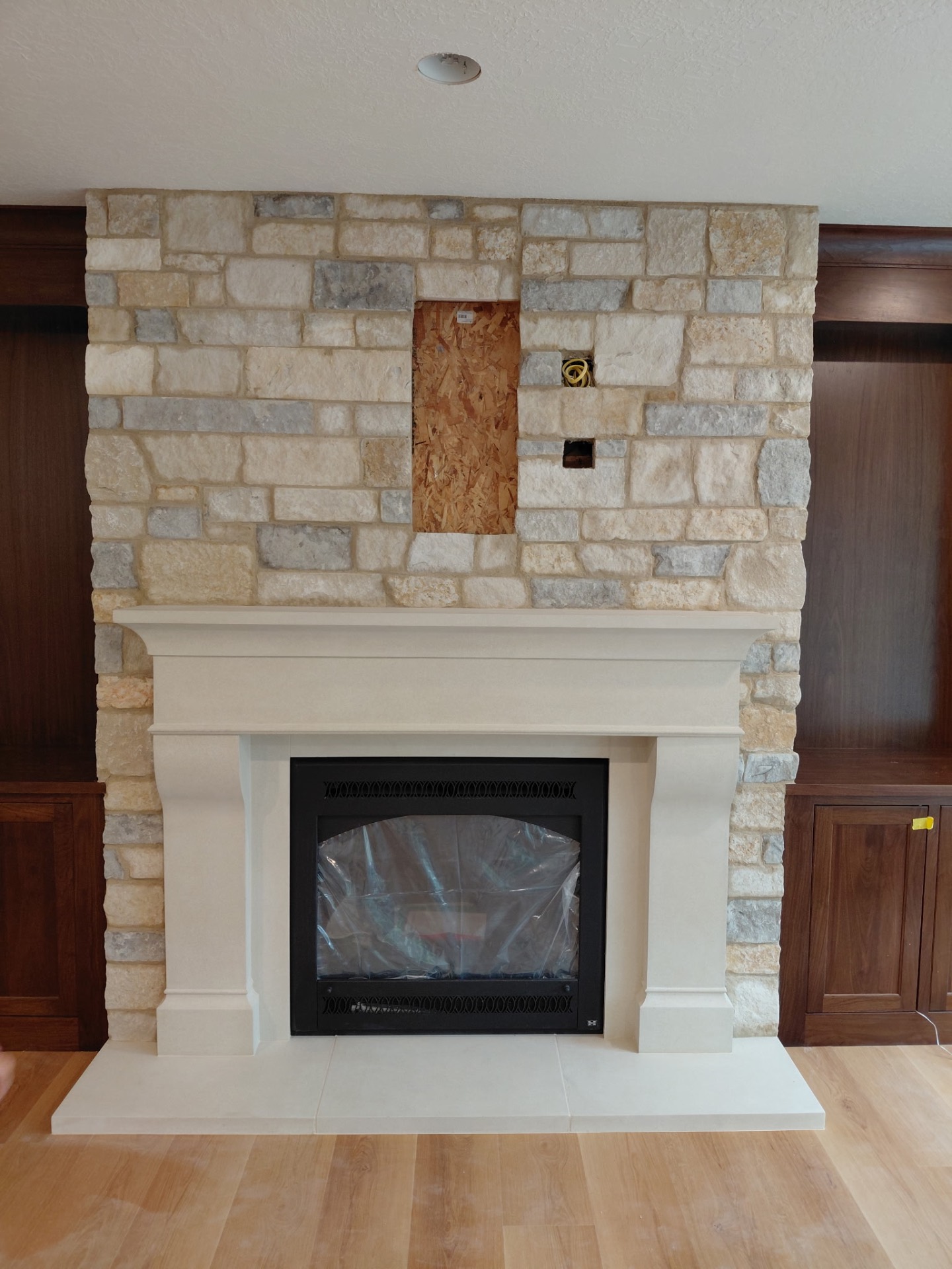 Living room stone fireplace with cast stone mantel
