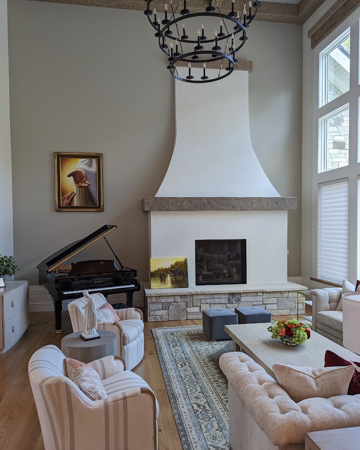 Two-story white plaster range hood fireplace with stone hearth