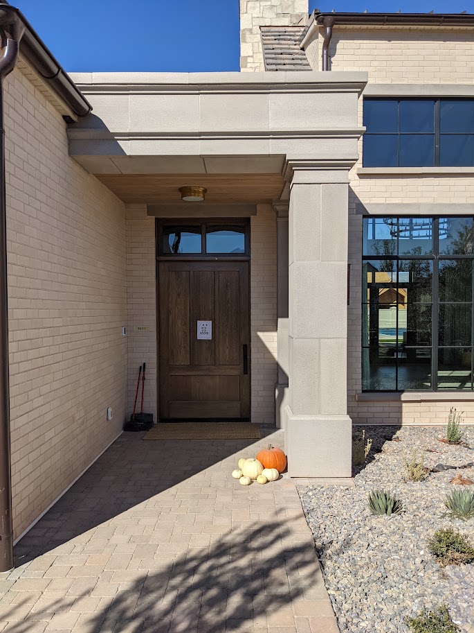 Cast limestone entry column, header, and cornice detail on a brick home