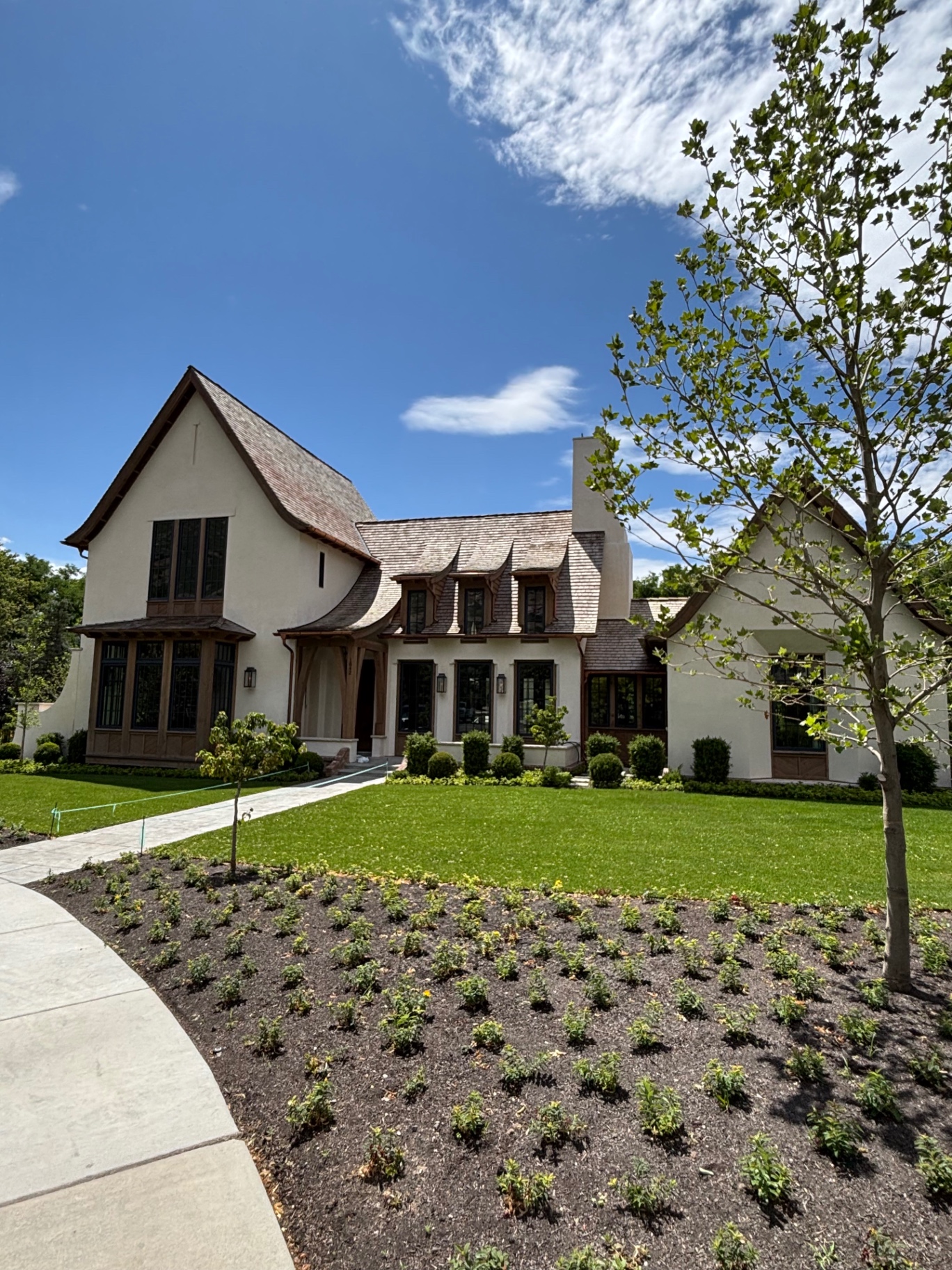 Storybook stucco home exterior with shingle roof in Utah