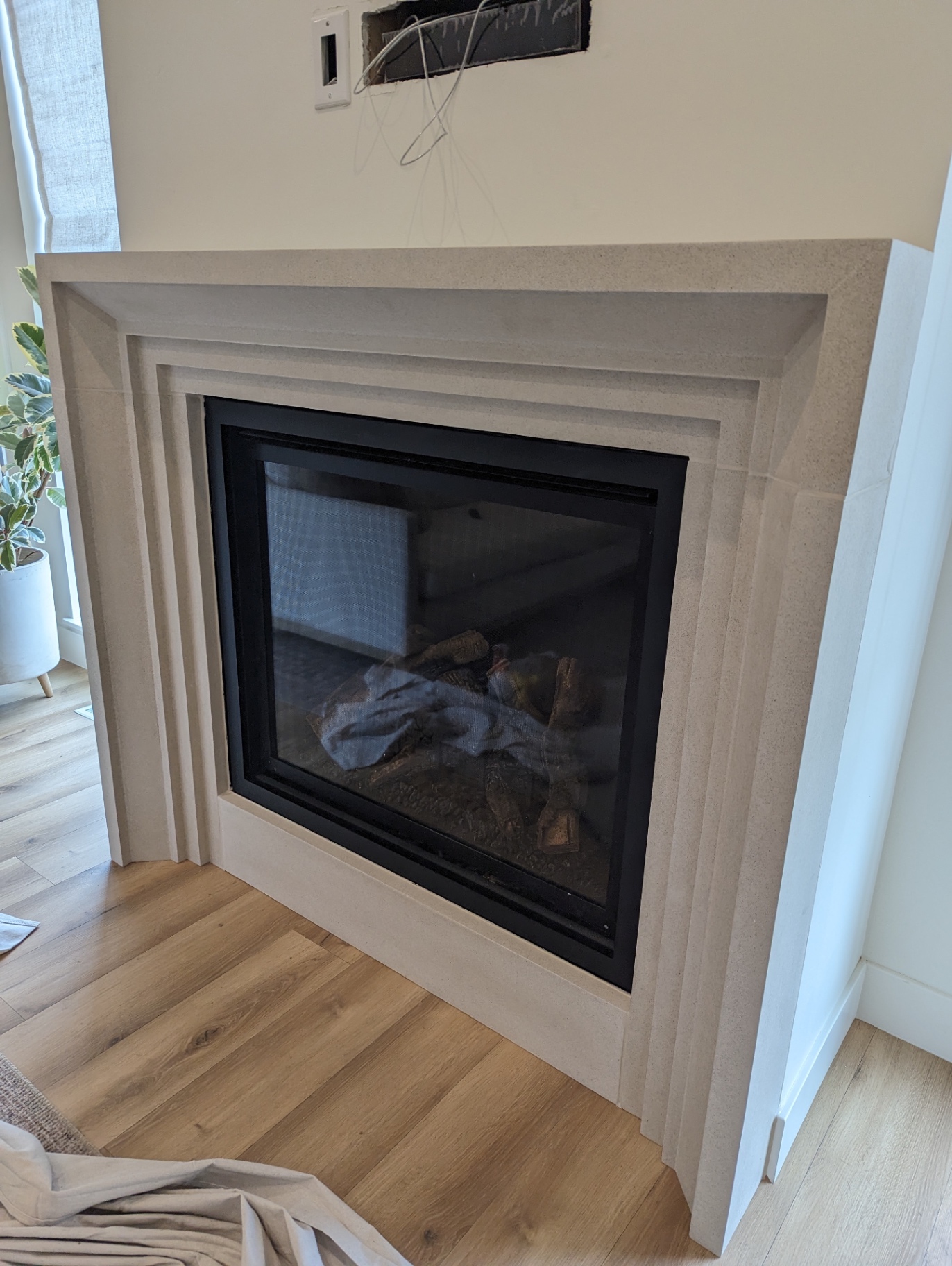 Cast stone fireplace surround with smooth plaster finish