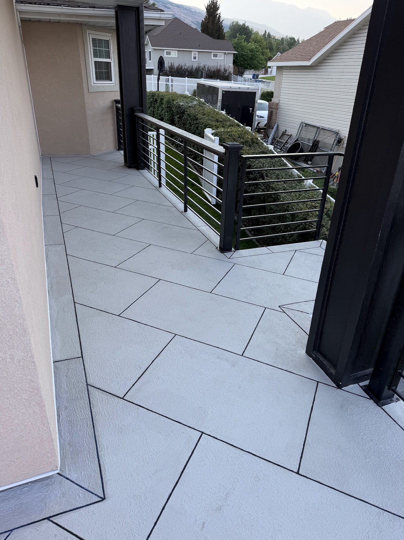 Waterproof deck with custom gray tile pattern and railings