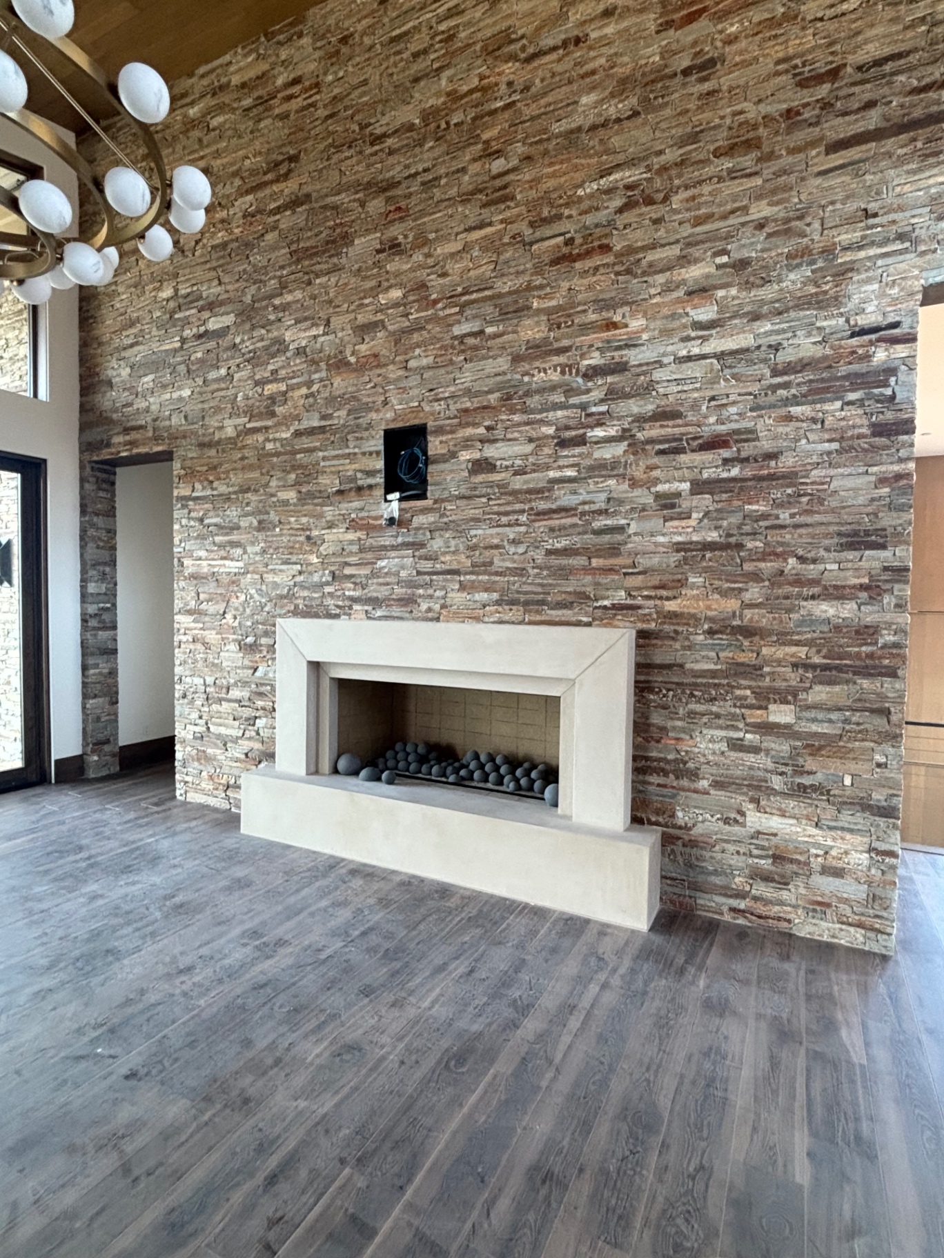 Great room stacked stone wall with cast stone fireplace surround