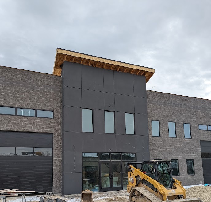 Commercial building with dark stucco panel facade under construction