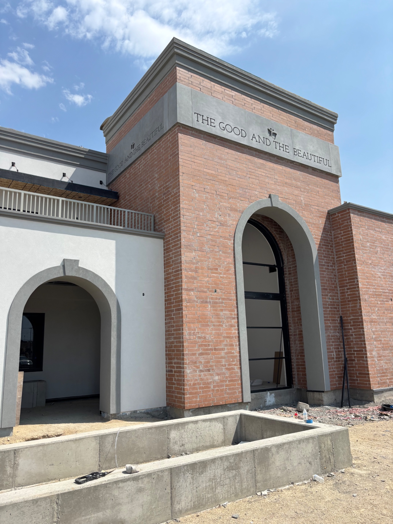 Brick and cast stone commercial facade with arched entries