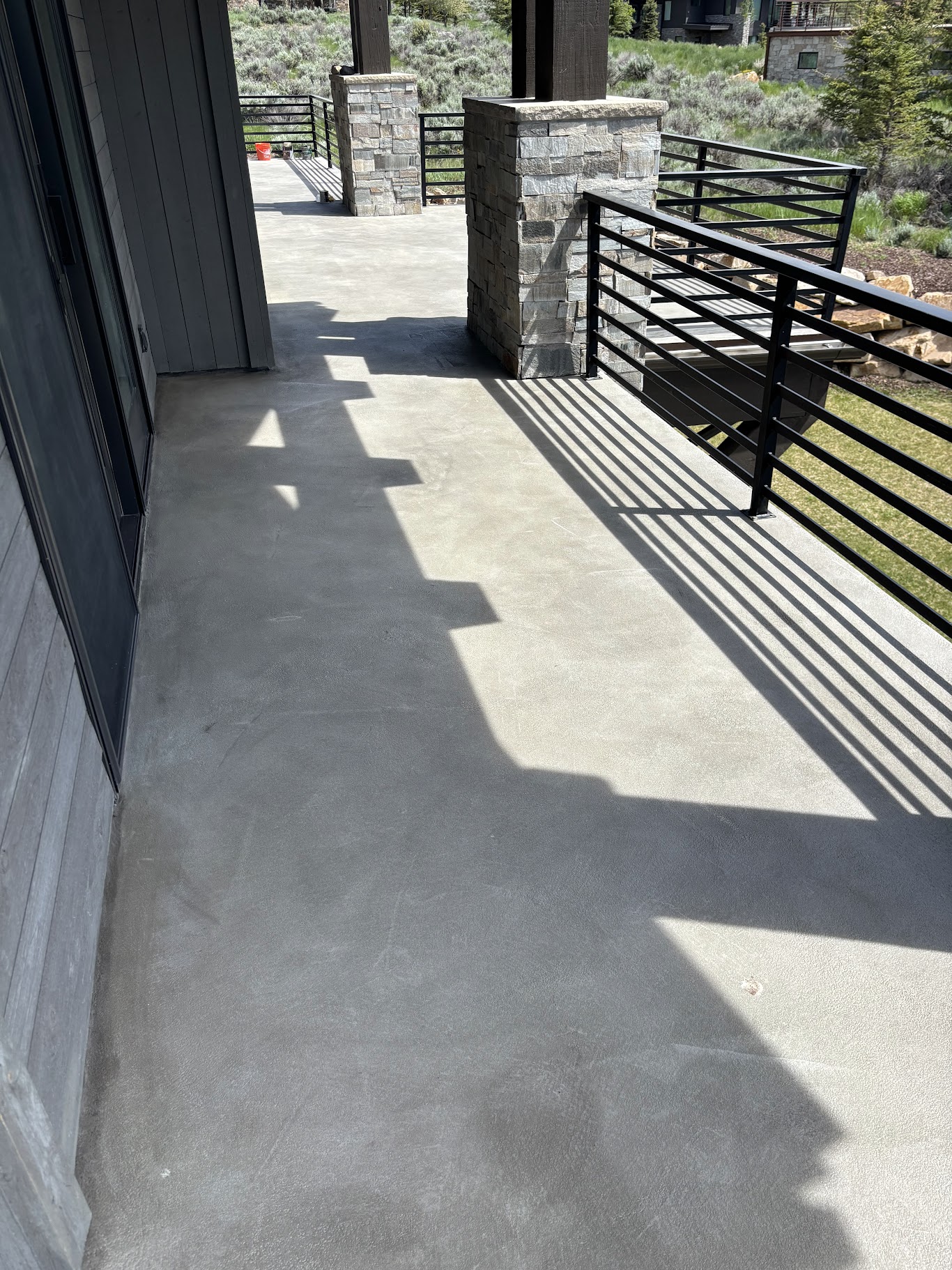 Concrete deck coating with black railings and mountain scenery