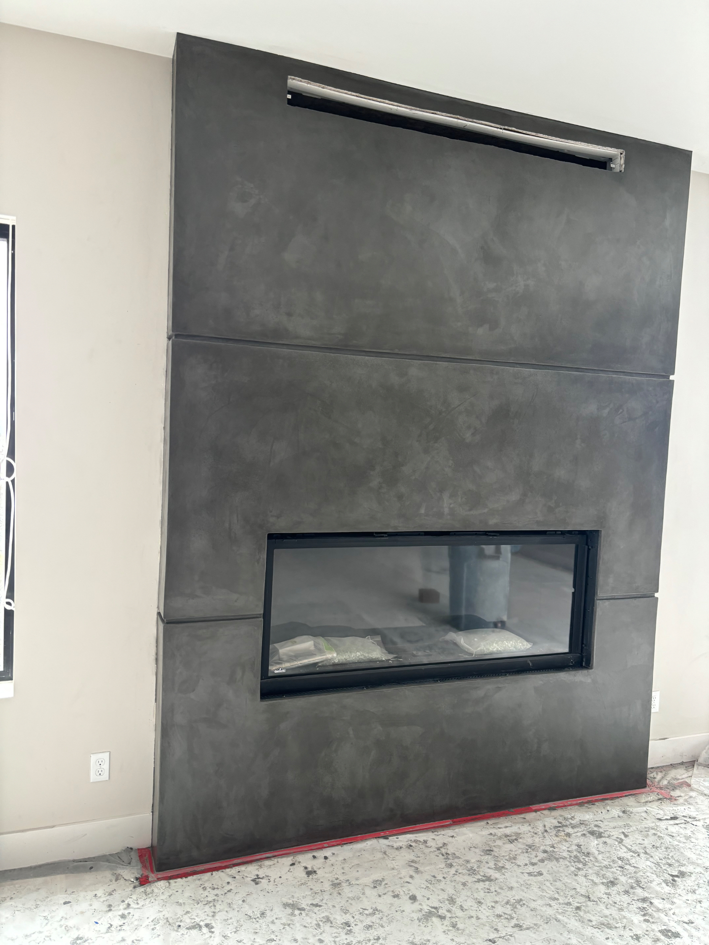 Charcoal Venetian plaster fireplace wall with linear firebox