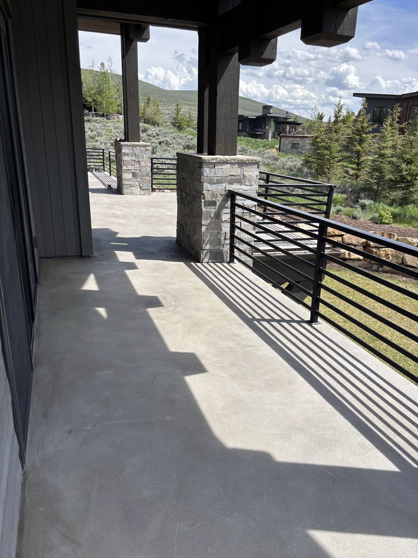 Covered concrete deck with stone pillars and mountain backdrop